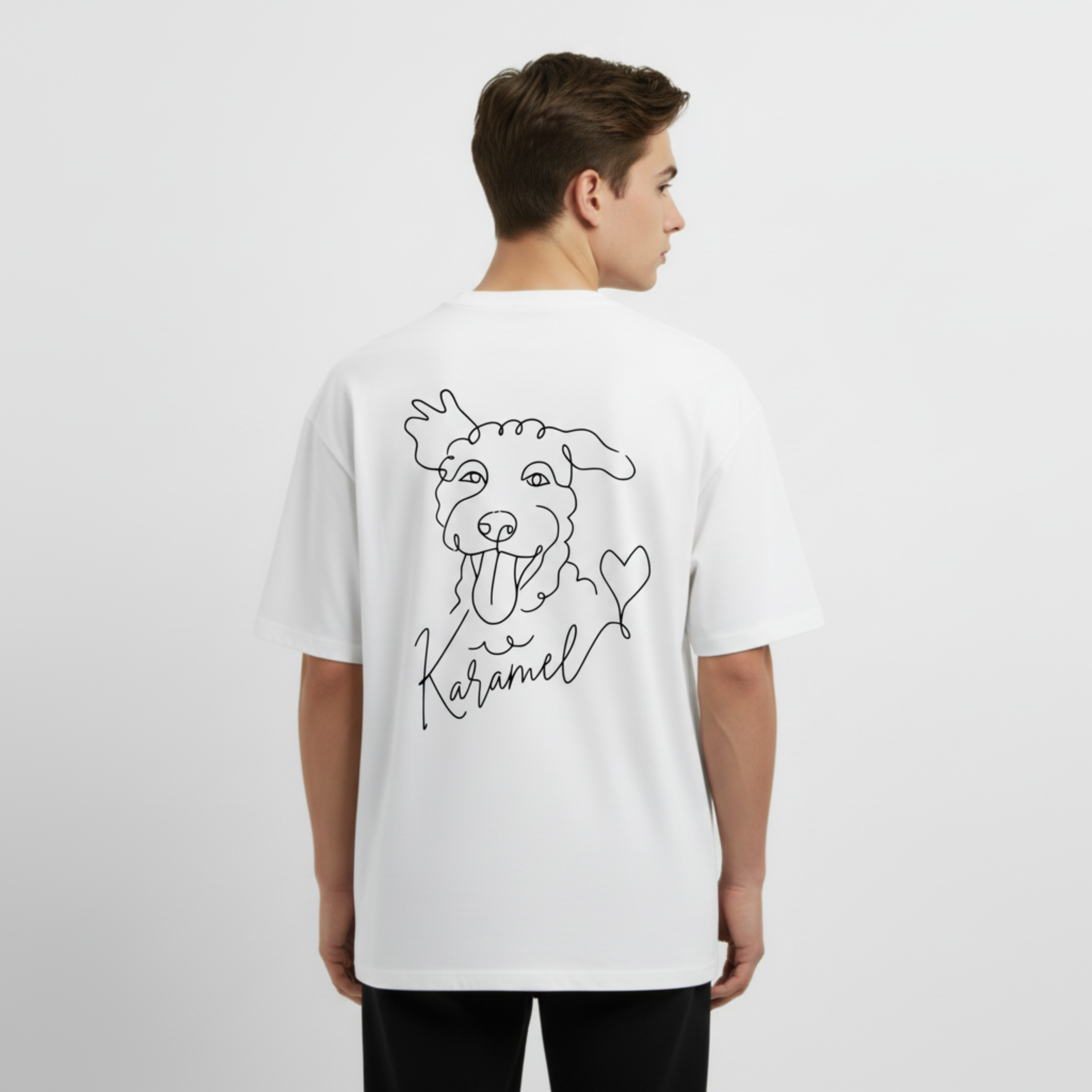 Person wearing a white t-shirt with a dog illustration and text on the back, standing against a plain background. Just Groom Me – Trimsalon Alphen aan den Rijn | Professional dog grooming & personalized pet apparel.