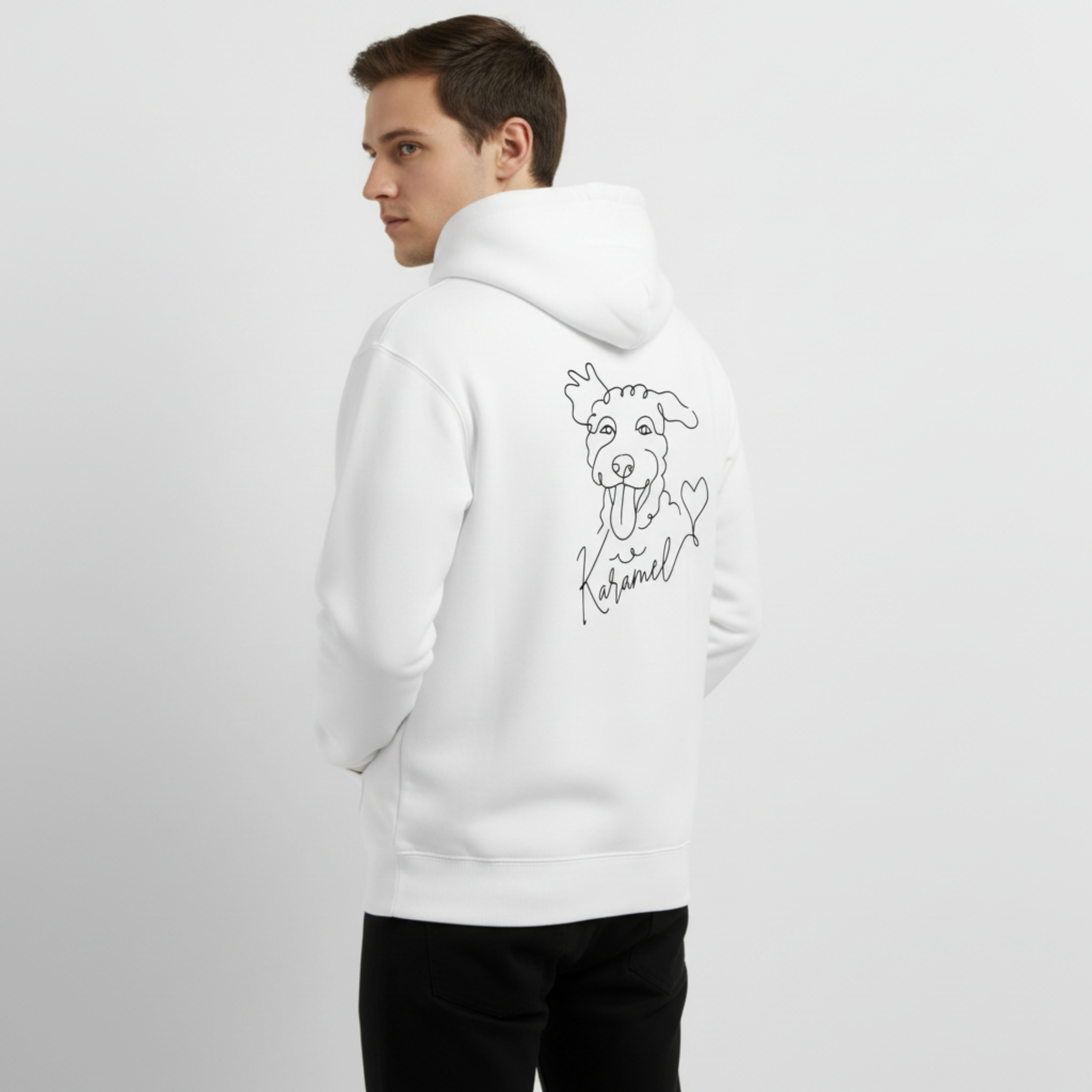 Person wearing a white hoodie with a dog illustration on the back against a plain background. Just Groom Me – Trimsalon Alphen aan den Rijn | Professional dog grooming & personalized pet apparel.
