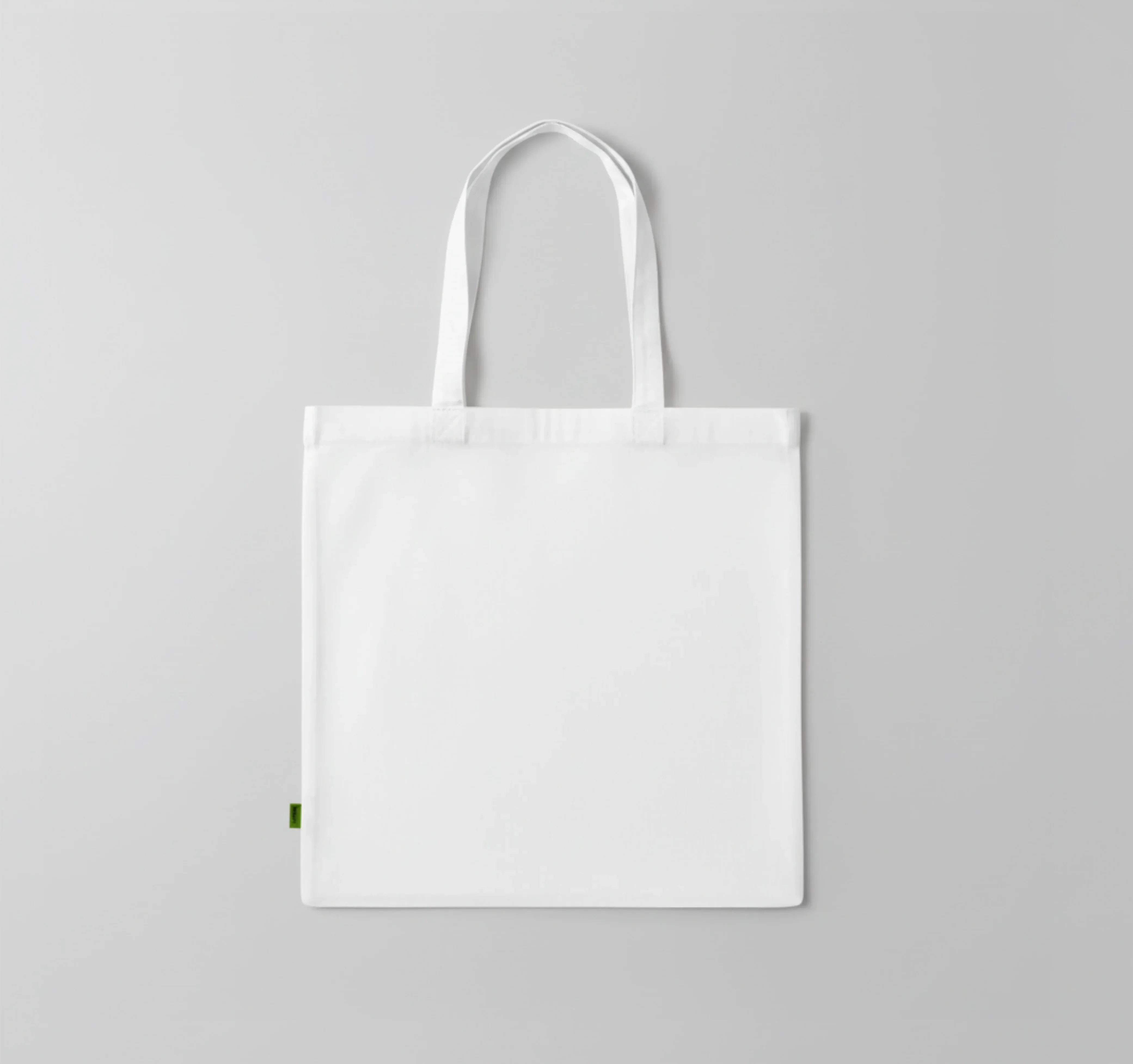 White tote bag on a gray background. Just Groom Me – Trimsalon Alphen aan den Rijn | Professional dog grooming & personalized pet apparel.