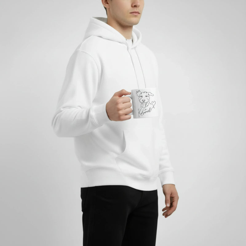 Person wearing a white hoodie holding a mug with a design on a plain background. Just Groom Me – Trimsalon Alphen aan den Rijn | Professional dog grooming & personalized pet apparel.